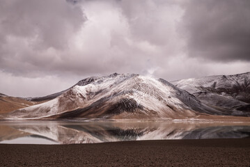 laguna diamante con reflejo de monta&ntilde;a nevada en cordillera de los andes