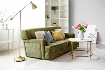 Interior of living room decorated for Easter celebration with sofa and tulips in vase