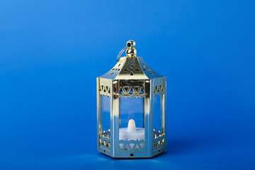 Muslim lantern with candle for Ramadan on blue background