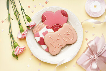 Composition with sweet cookies, carnation flowers, ribbon and gift on color background. Valentine's Day celebration