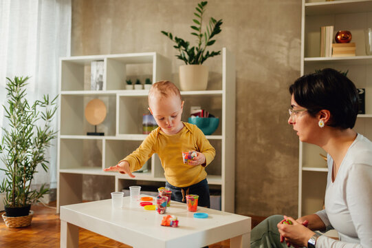 Mother and son playing with clay at home and creating art
