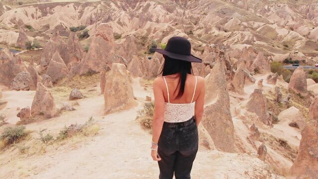 Caucasian Woman tourist enjoy freedom and travel holidays outdoors walk don among fairy chimneys in devrent valley , Cappadocia