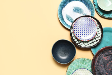 Set of different ceramic plates on color background