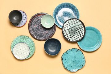 Set of different ceramic plates on color background