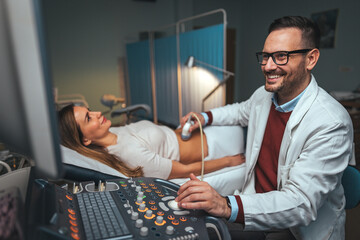 Gynecologist doctor does ultrasound, sonogram procedure to a pregnant woman. Doctor makes the patient women abdominal ultrasound. Ultrasound Scanner in the hands of a doctor. Diagnostics. Sonography