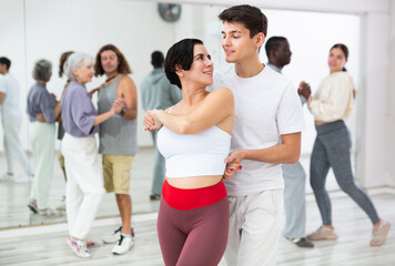 Caucasian man and lady rehearsing latin paired dance moves