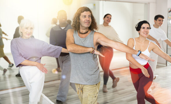 Positive man practicing active dancing during group training. High quality photo