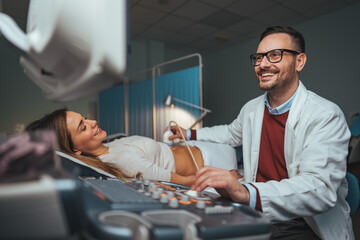 Sonographer using ultrasound machine at work. Modern clinical diagnostics and treatment. Close-up ultrasound scanner in hand of doctor. Doctor ultrasound examine female patient abdomen at hospital