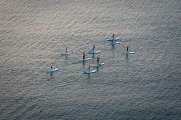 Paddleboarding or stand up paddle class in the coastline of Lagos, Algarve, Portugal at sunrise