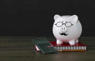 Calculator, pen and red notebook with piggy bank on table. Financial concept. 