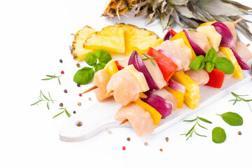 Chicken Skewers breast fillet meat.Skewers with pieces of raw meat, red, yellow pepper.Top view.Uncooked meat skewer.Raw pieces of chicken skewers with pepper onion and pineapple white background.