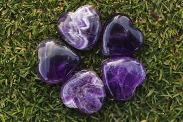 amethyst heart stones in a circle on grass 