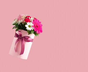 Pink gift box with various flowers on pink background. Valentines day aesthetic nature concept. 8 March card idea. Copy space.