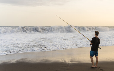 Young man fishing on the beach
