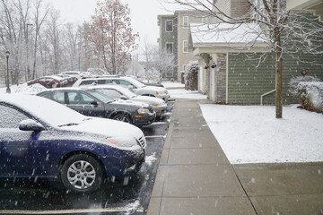 cars parked outside apartment building in winter snow