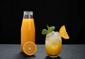 a glass with orange juice on a dark background