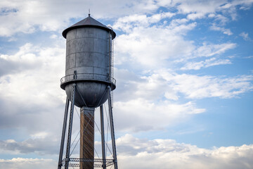 Silver Antique Water Tower Against a Partially Cloudy Sky