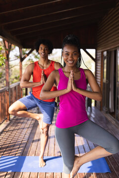 Portrait of happy african american man spending time in log cabin practicing yoga