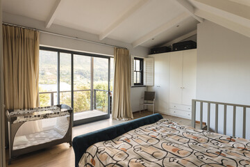 Empty cosy bedroom with big window on balcony and cradle