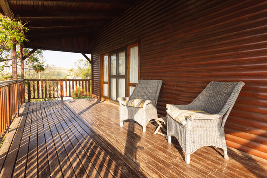 Empty cosy balcony of log cabin with two chair on sunny day