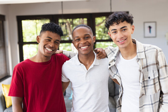 Image of happy diverse male teenage friends looking at camera