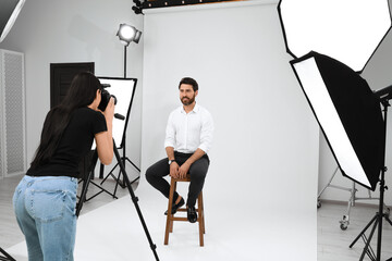 Handsome model posing for professional photographer in studio - Powered by Adobe