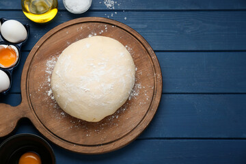 Fresh yeast dough and ingredients on blue wooden table, flat lay. Space for text