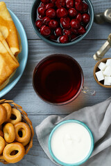 Flat lay composition with aromatic tea and treats on light blue wooden table