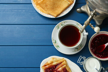 Aromatic tea, traditional Russian samovar and treats on light blue wooden table, flat lay. Space for text