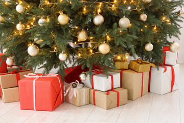 Fototapeta na wymiar Beautiful Christmas tree with festive lights and gifts indoors