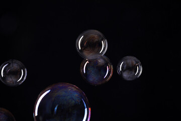 Beautiful soap bubbles on black background. Space for text