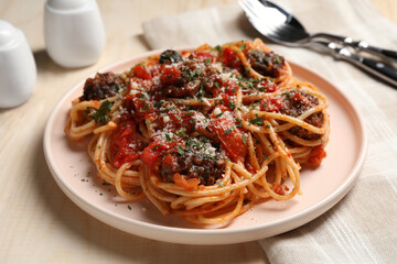 Delicious pasta with meatballs and tomato sauce served on wooden table