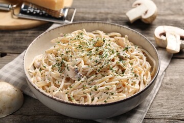 Delicious pasta with mushroom sauce on wooden table