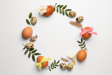 Frame of Easter eggs, twigs and flowers on white background. Space for text