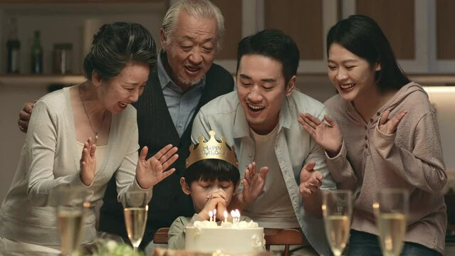 three generation asian family celebrating little boy's birthday at home
