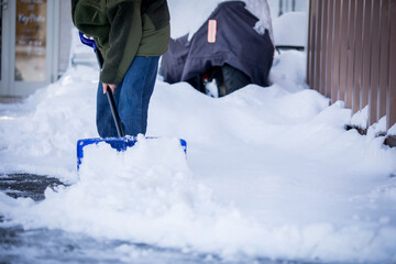 雪かきをする女性　shoveling snow