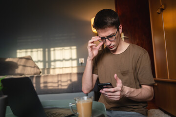 A young guy is using his laptop to study or do business from home