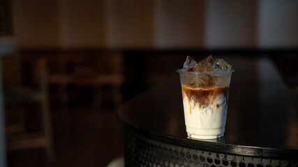 Iced Latte Coffee in a Plastic Glass on a Black Table at a Coffee shop
