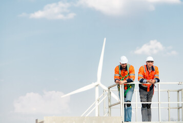 Surveyor and engineer Examine the efficiency of gigantic wind turbines that transform wind energy...