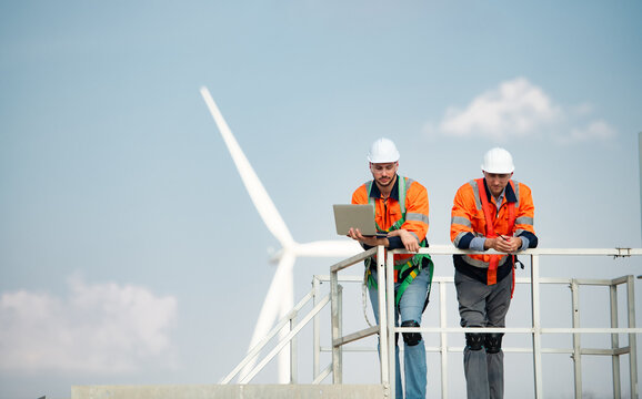 Surveyor and engineer Examine the efficiency of gigantic wind turbines that transform wind energy into electrical energy that is then used in daily life.