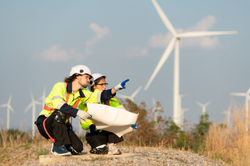 Man and female engineer stationed at the Natural Energy Wind Turbine site. with daily audit tasks of major wind turbine operations that transform wind energy into electrical electricity