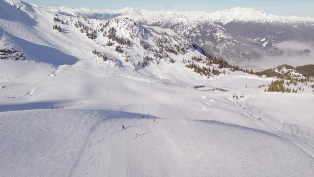 Downihll skier aerial footage, drone, ski mountain, sunny day, winter, mountain vista, ski hill. 4K 24FPS