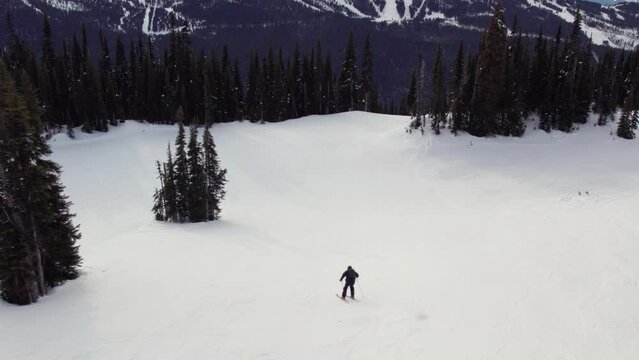 Downihll skier aerial footage, drone, ski mountain, sunny day, winter, mountain vista, ski hill. 4K 24FPS