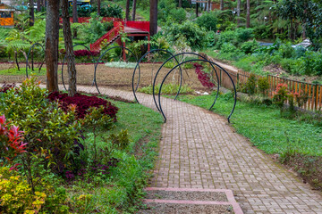 The lush garden is equipped with paving blocks for tourists to walk while enjoying the shade of forest trees.