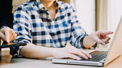 Mature businessman using a digital tablet to discuss information with a younger colleague in a modern business lounge