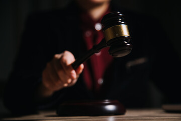 Justice and law concept.Male judge in a courtroom with the gavel, working with, computer and docking keyboard, eyeglasses, on table in morning light