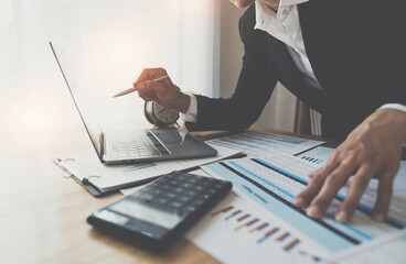 Financial analyst or Asian businesswoman analyzing and compare detailed financial reports, taxes,...