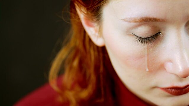 The moment when the calm but emotional woman wipes away her tears after they fall in slow motion for a while