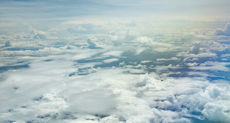 The view from the window on the plane, many white clouds in the sky.