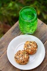 cookies on white plate and green soda drink on table
